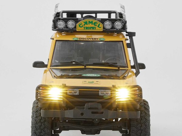 Távirányítós crawler autó Camel Trophy festéssel, elölnézeti kép, bekapcsolt LED lámpákkal